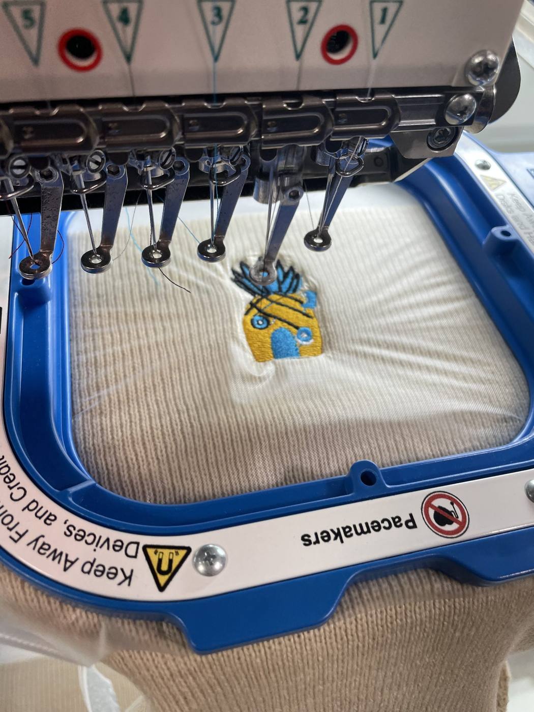 Commercial embroidery machine stitching a logo onto apparel