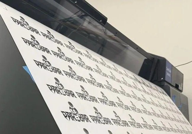 Custom vinyl stickers coming off a wide-format printer