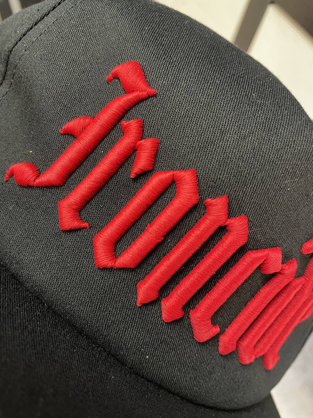 Black hat with raised red puff embroidery lettering